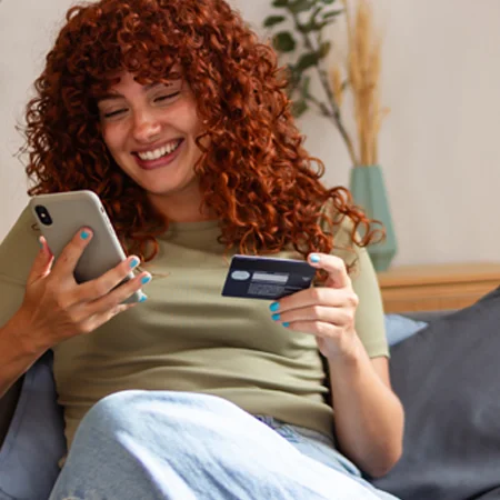 person holding a phone and a credit card