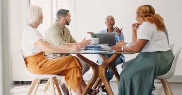 Group of workers sitting around a conference table discussing a strategic plan.