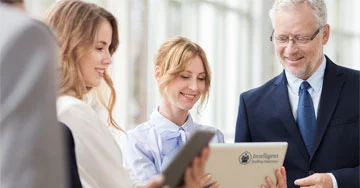 group of people looking at a tablet talking