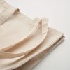 a folded beige cloth on a white surface