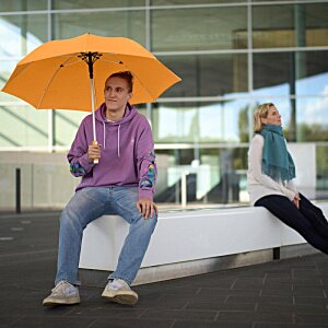 Additional Image 11 - a woman sitting on a bench holding an umbrella