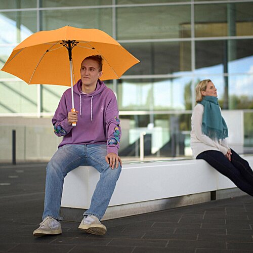 Additional Image 11 - a woman sitting on a bench holding an umbrella