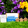 a group of small houses and a sign in the grass