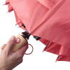 a hand holding a pink umbrella