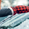 a person's hand in a red and black checkered glove on a car