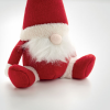 a small red and white stuffed gnome