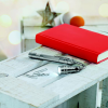 a red book and a pen on a white table