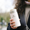 a woman holding a white cup