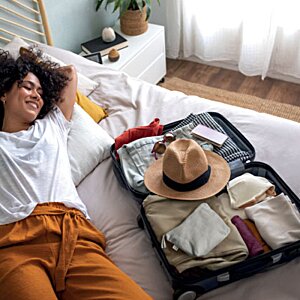 Additional Image 5 - a woman lying on a bed with a suitcase
