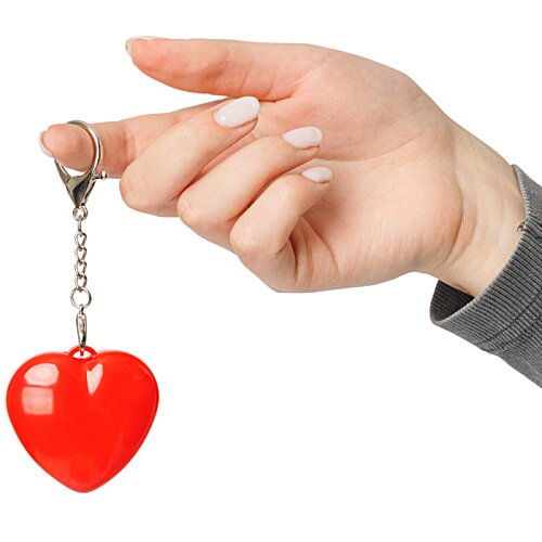 Additional Image 1 - a hand holding a key chain with a heart shaped object
