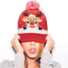 a woman wearing a red hat with a reindeer design on it