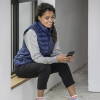 a woman sitting on a ledge looking at her phone
