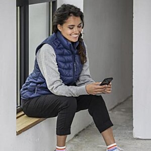 Additional Image 1 - a woman sitting on a ledge looking at her phone
