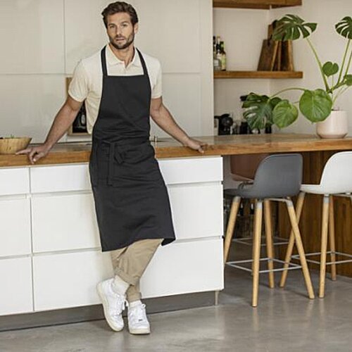 Additional Image 1 - a man in an apron leaning against a counter