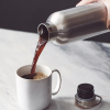 a person pouring a liquid into a cup