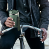 a man holding a green cup on a bicycle