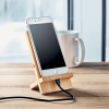 a phone charging on a wood stand