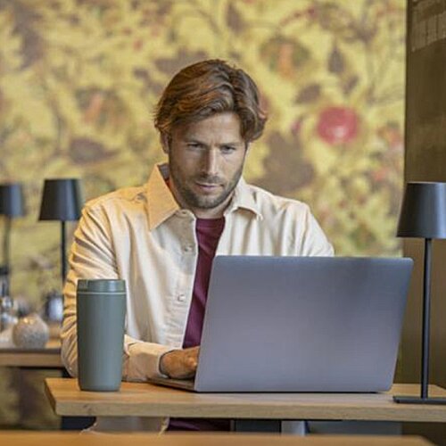 Additional Image 11 - a man sitting at a desk with a laptop