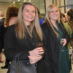 Two smiling people holding drinks.