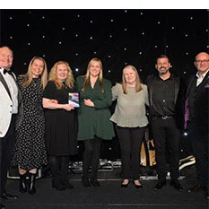 Group of smiling people standing on stage.