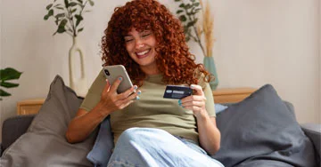 person holding a phone and a credit card