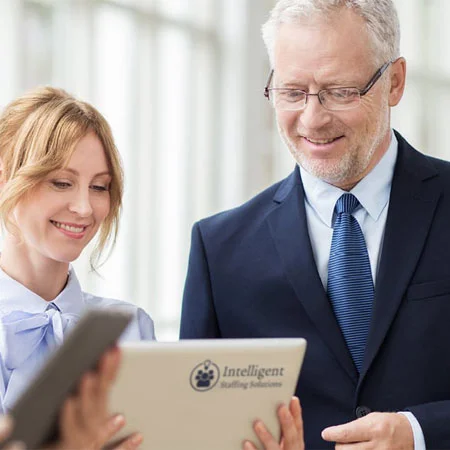 group of people looking at a tablet talking