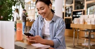 Smiling person sitting at a desk with a reusable water bottle.